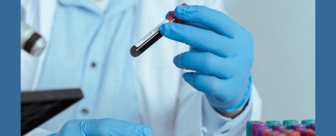 A healthcare professional holding a blood tube.